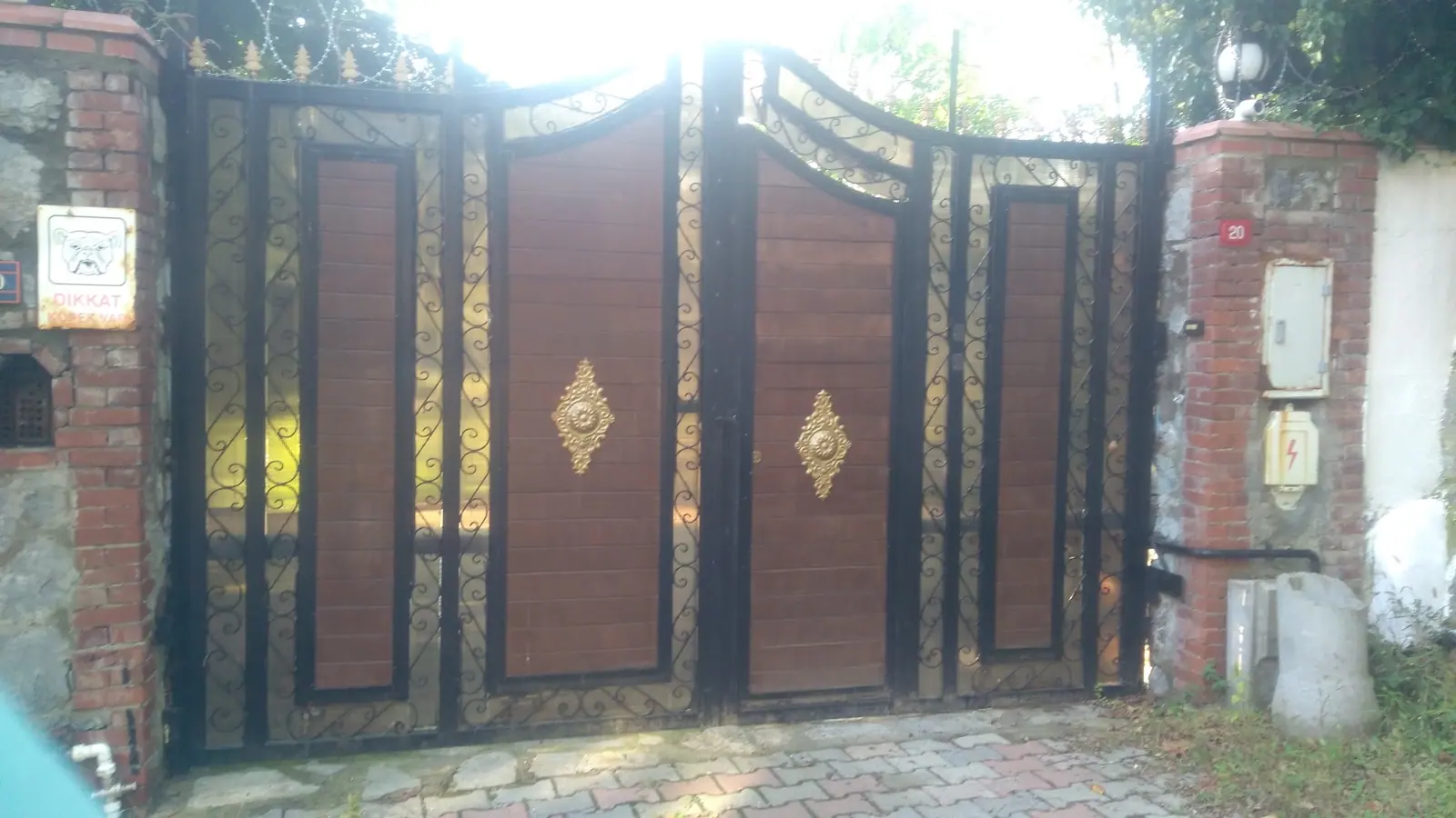 Ahşap görünümlü kaplama ve altın çıtalarla hazırlanmış bina giriş kapısı