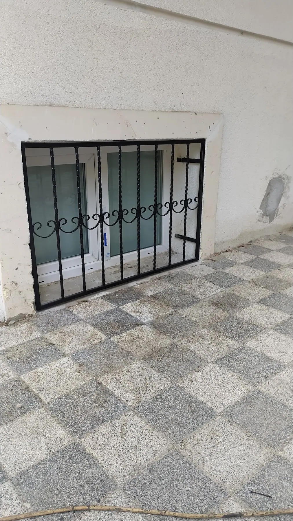 İç mekândan görünen, dikey dikmeli siyah pencere parmaklığı
