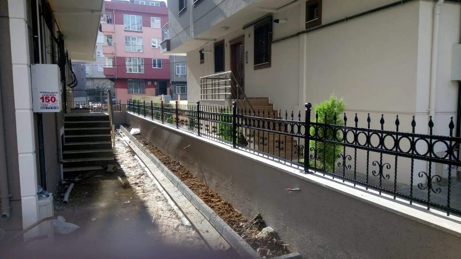 Bina yan yolu boyunca devam eden istinat duvarı üzeri demir korkuluk