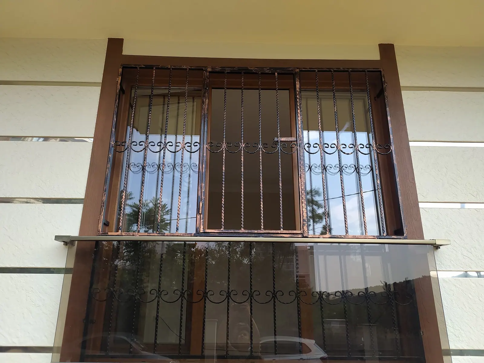 Pencere ve balkon boyunca devam eden kahverengi ferforje korkuluk