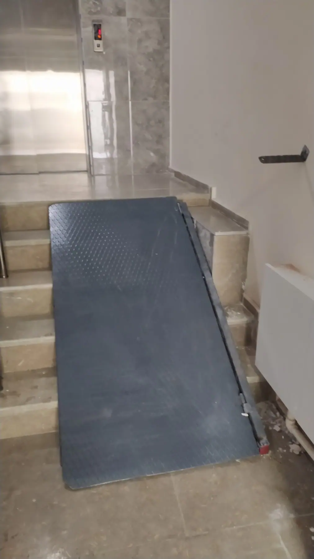 Merdiven üzerine yerleştirilmiş kaymaz yüzeyli metal engelli rampası
