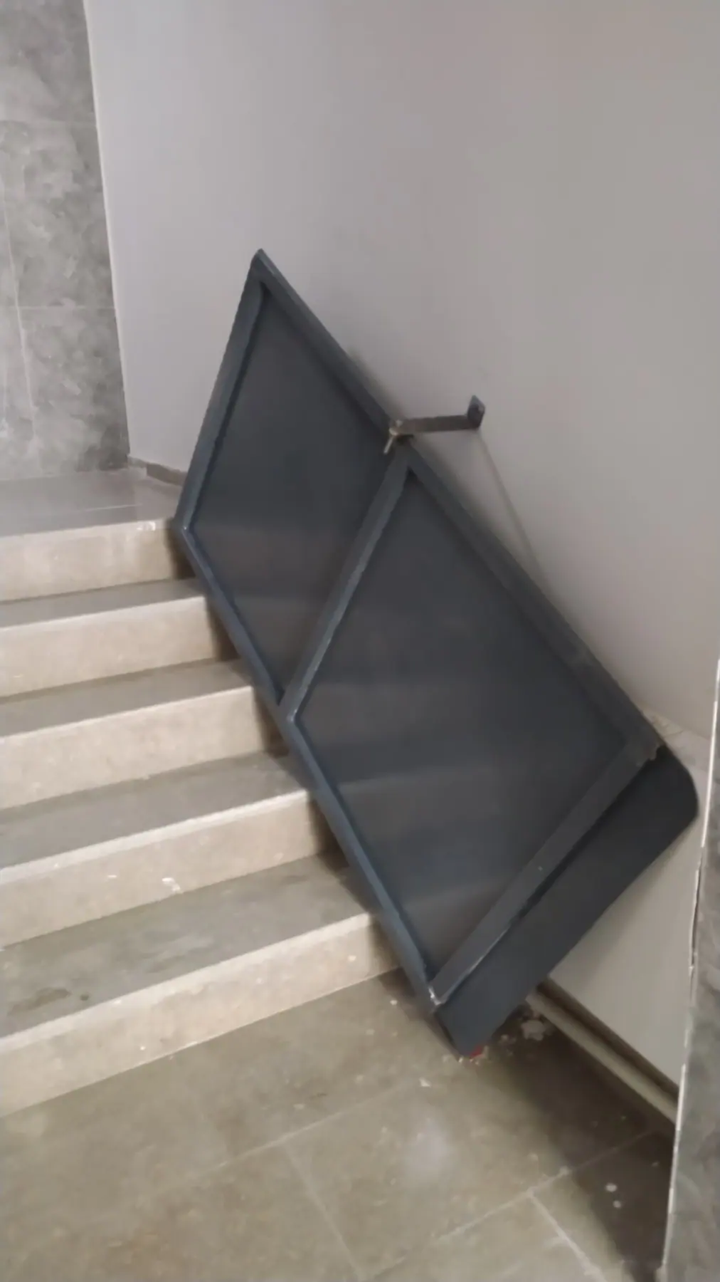 Montaj öncesi merdivene yaslanmış, boyanmış metal rampa paneli