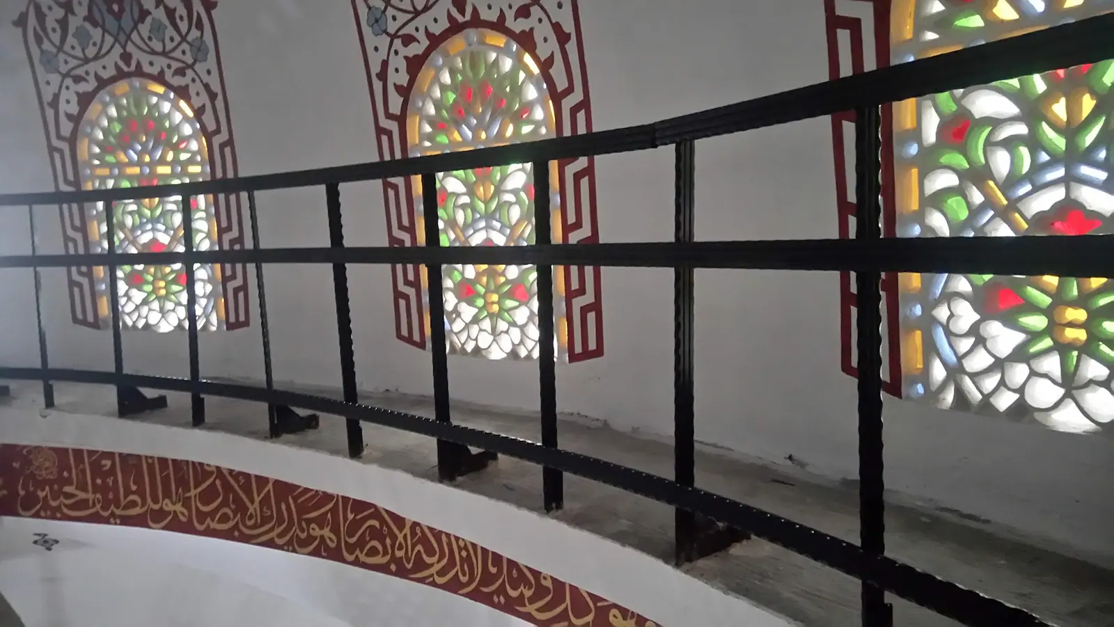 Vitraylı pencere boyunca uzanan kavisli iç merdiven korkuluğu